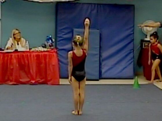 A gymnast saluting the judges at the start of her floor routine