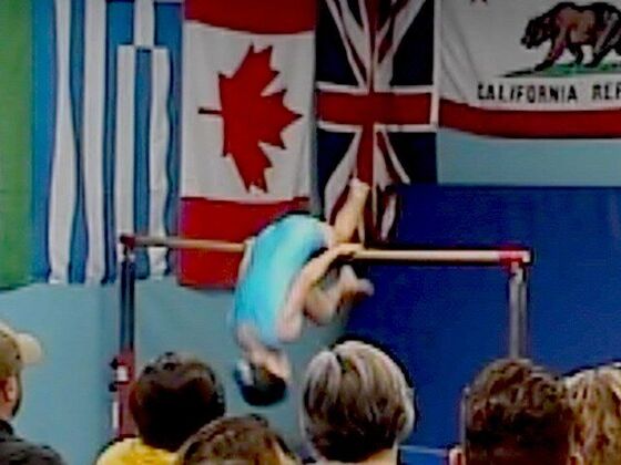Swinging on the bar in front of the flags at Champion Day