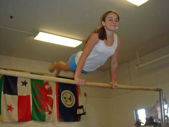A gymnast holding a front support on the bar